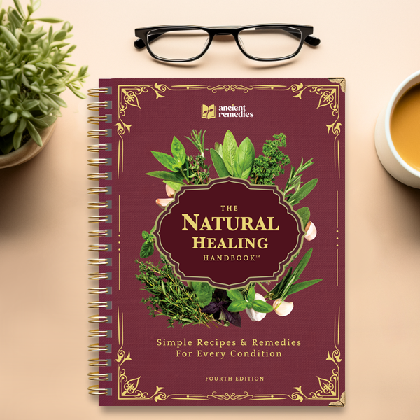 The Natural Healing Handbook beside a cup of tea